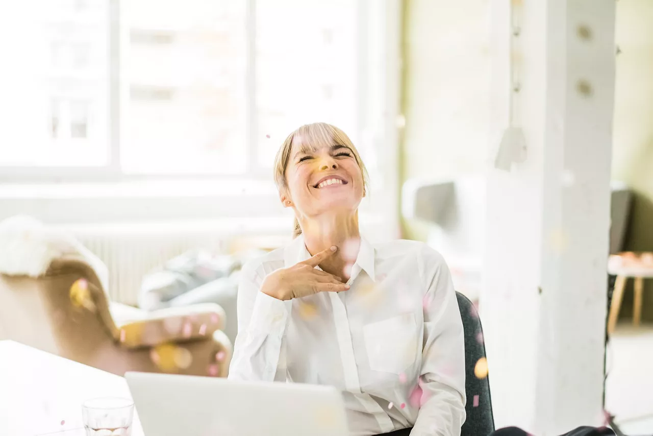 Primer plano de una chica sonriendo sentada en un interior