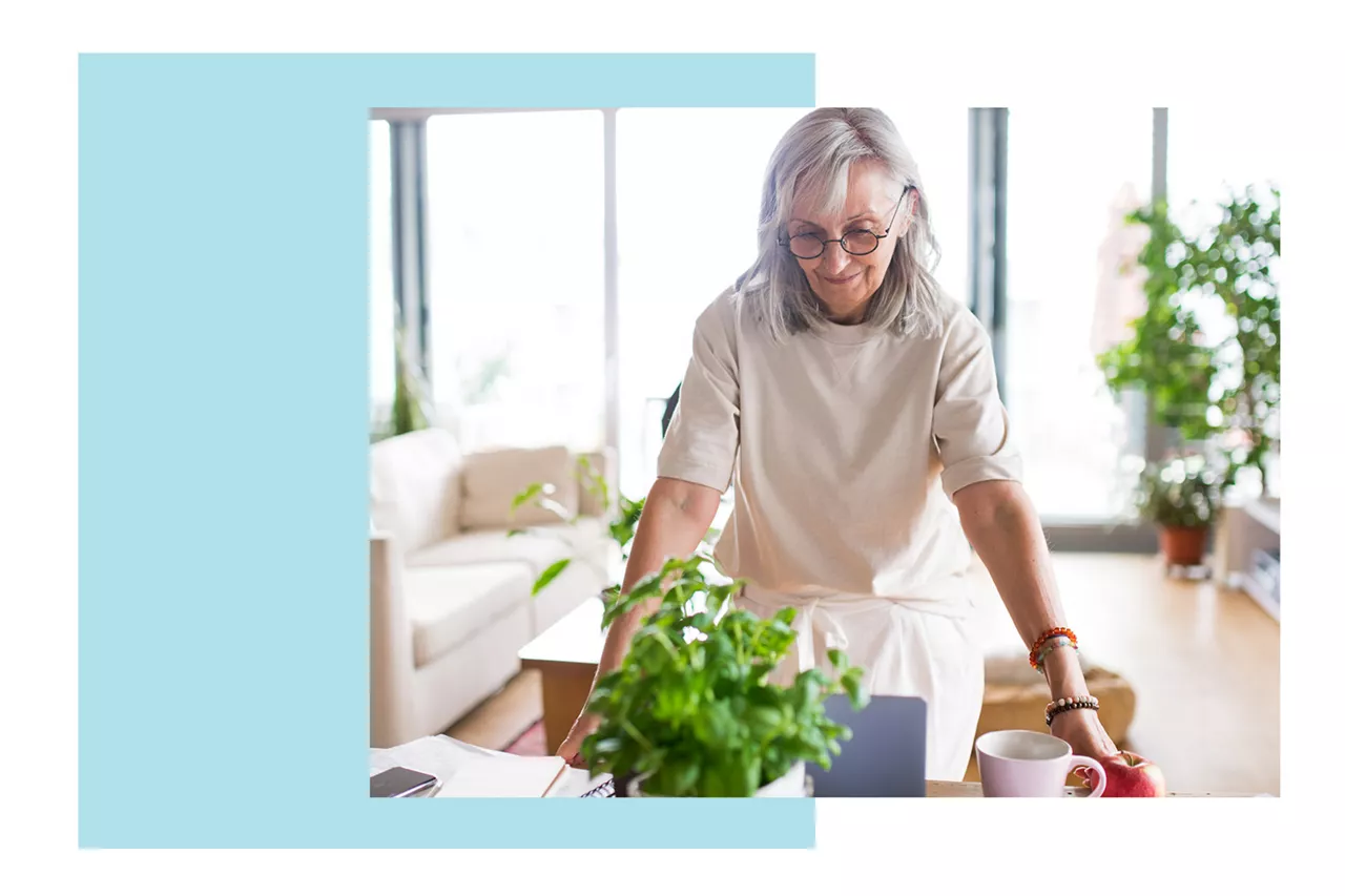 Una mujer junto a una mesa en el salón de casa decorado con plantas