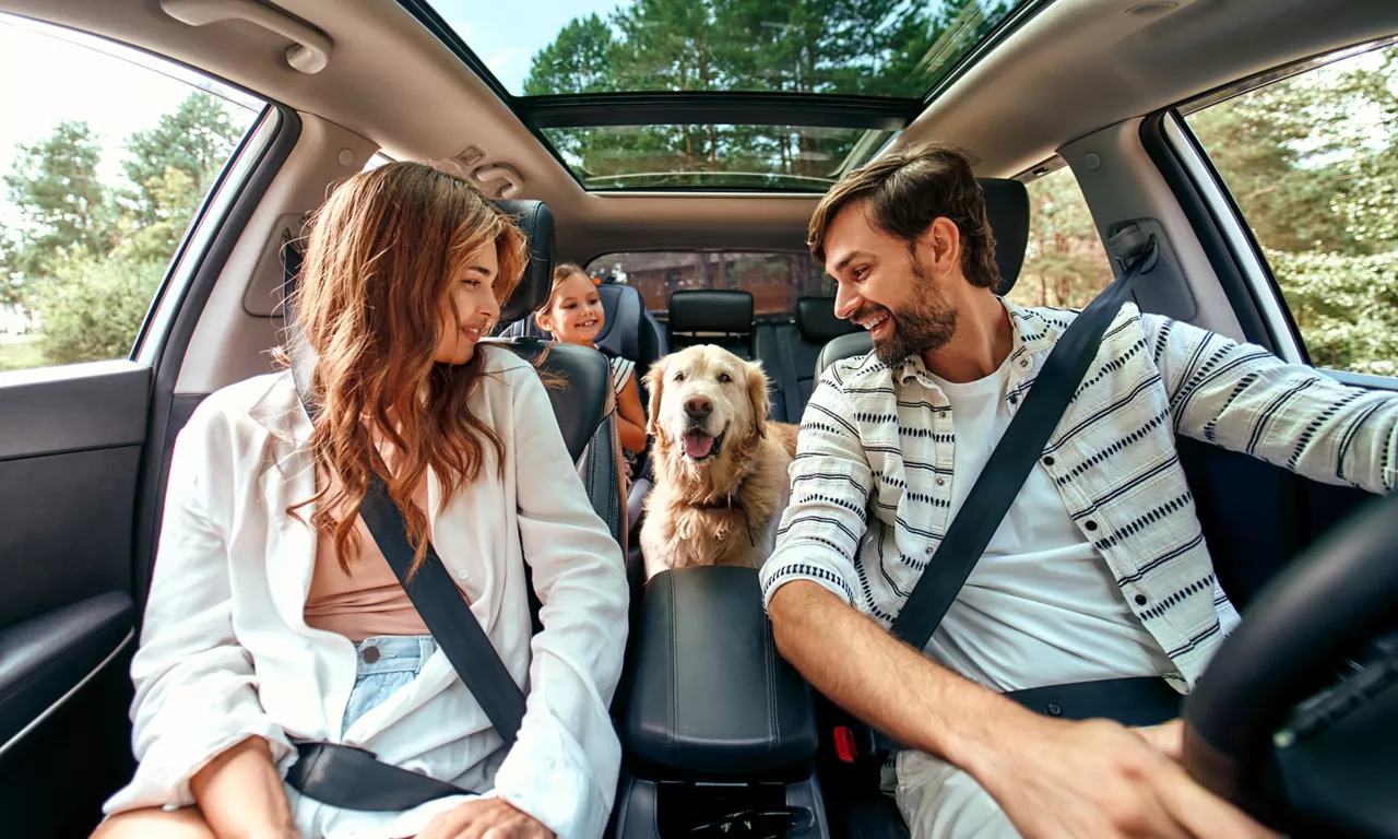 Familia sonriendo dentro de un coche de Renting del Grupo Volkswagen FS