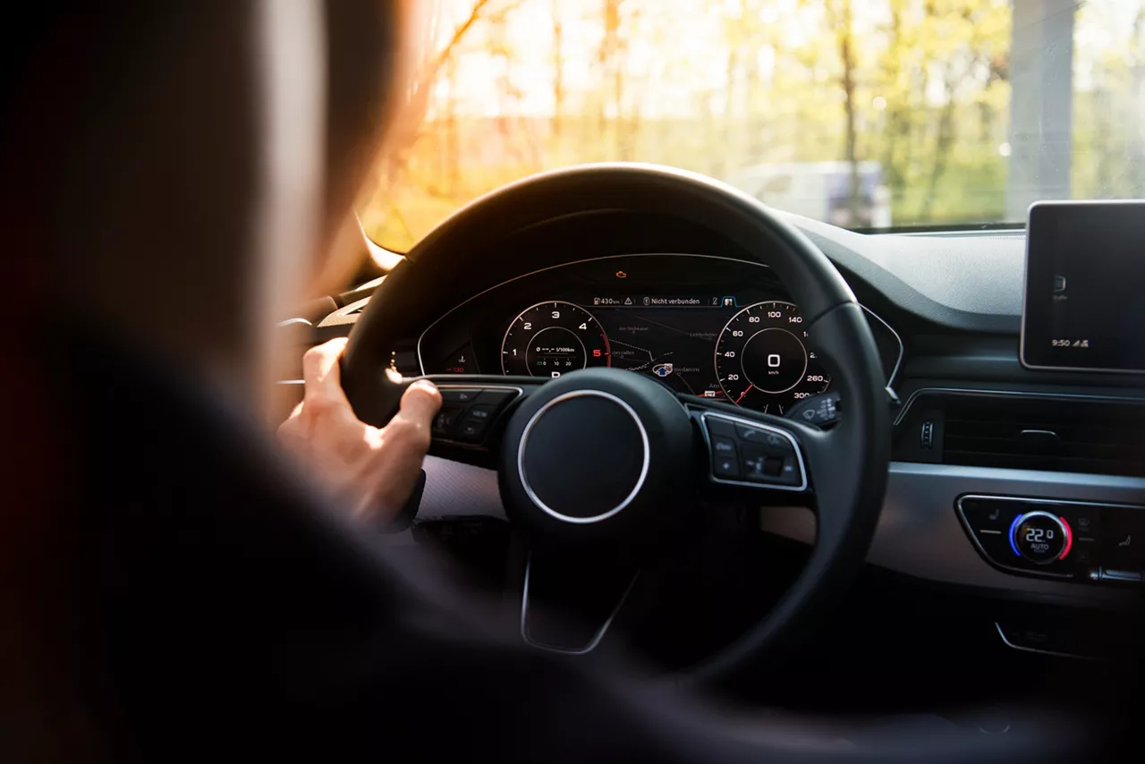 Fahrer vor Lenkrad im Dienstwagen.