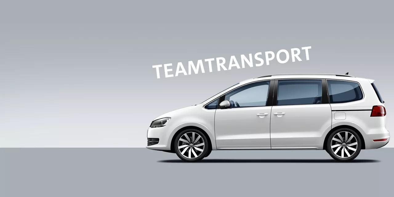 weisser-vw-sharan-vor-grauem-hintergrund-mit-schriftzug-teamtransport-dadrüber