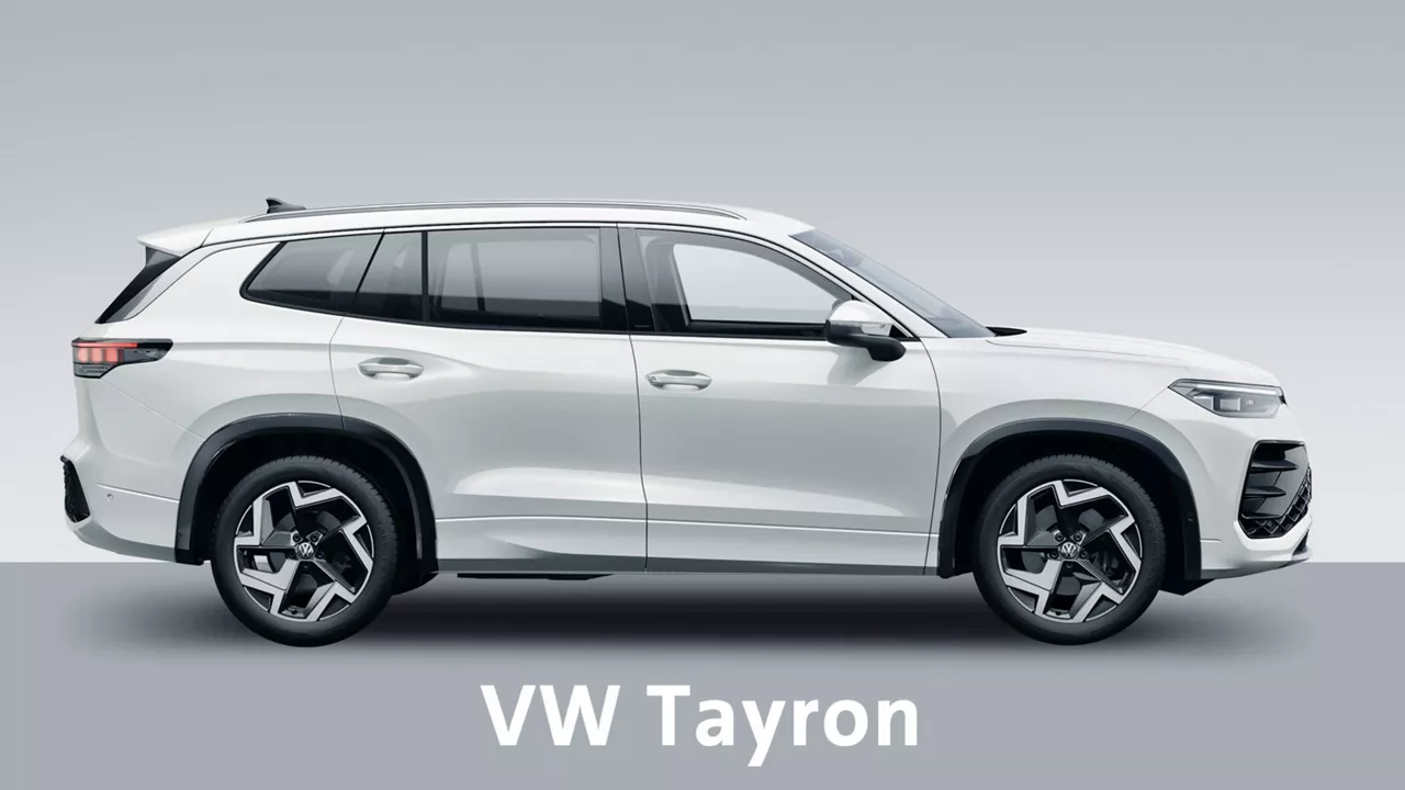 Weißer VW Tayron steht schräg seitlich vor grauem Hintergrund