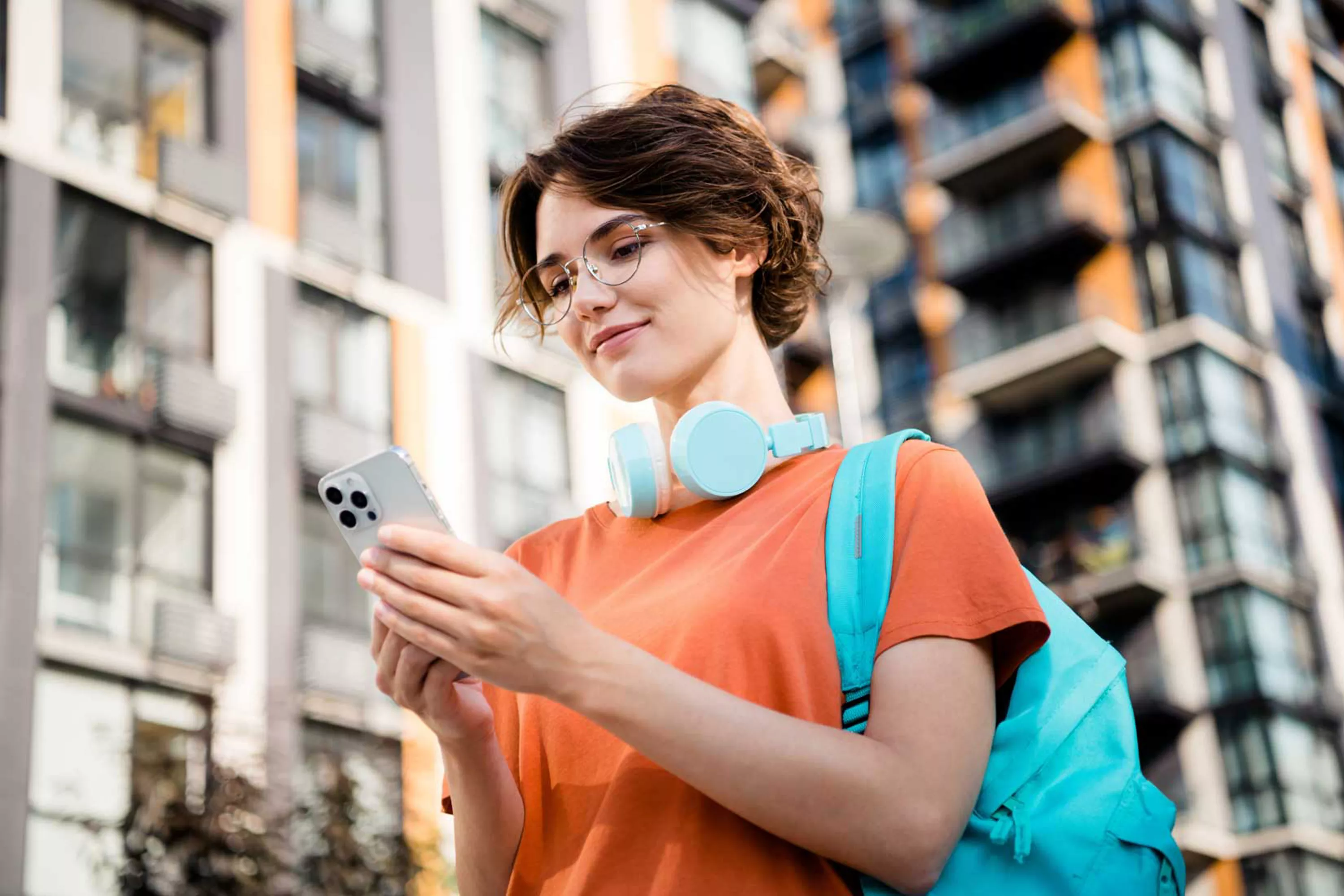 Uśmiechnięta dziewczyna przegląda telefon.