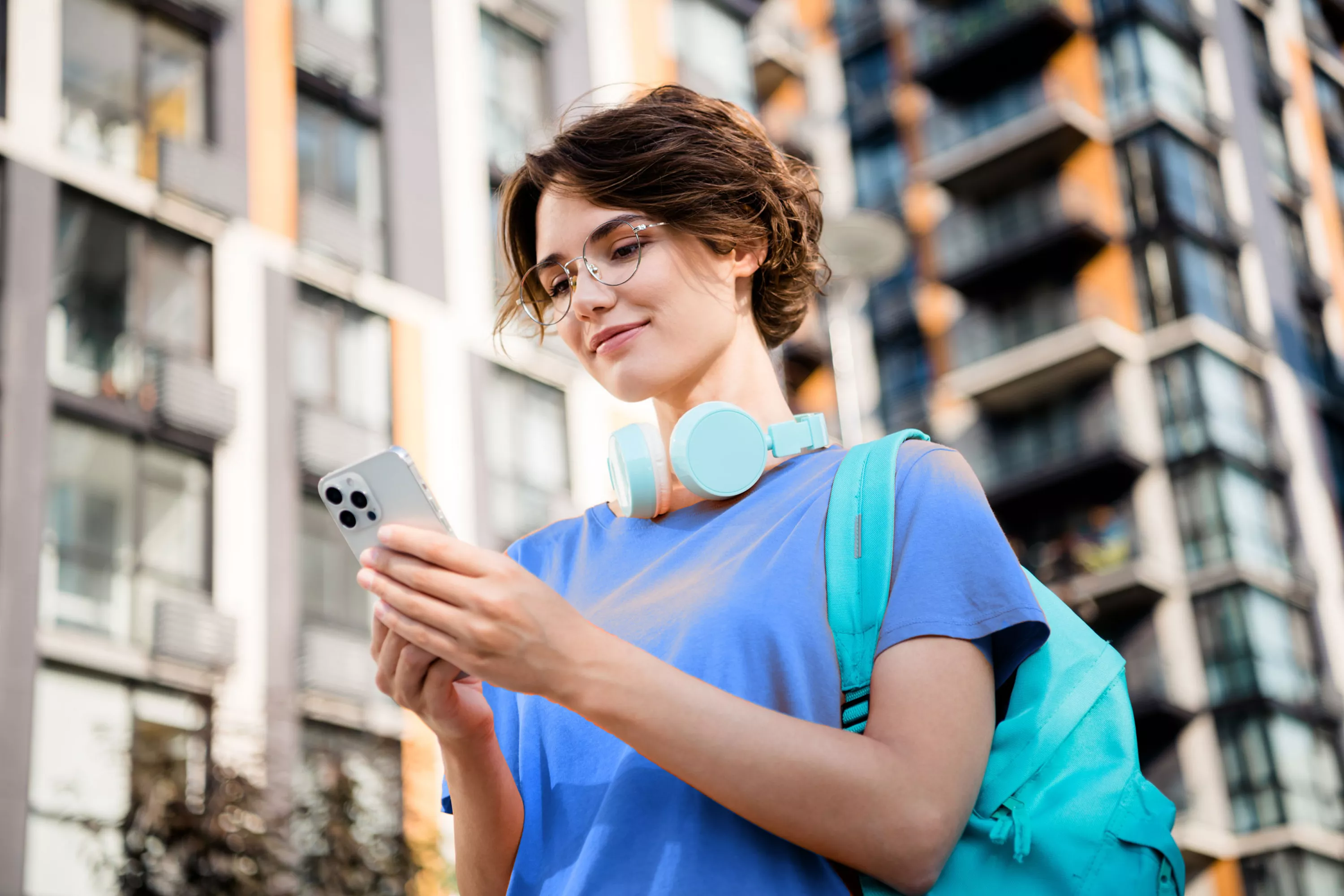 Uśmiechnięta dziewczyna przegląda telefon.