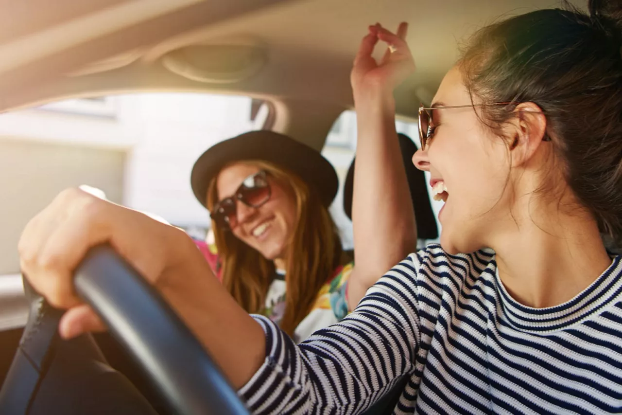 Chicas sonriendo dentro de un coche financiado con NEXT