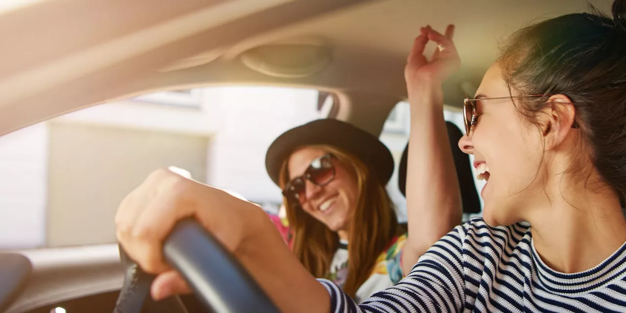 Chicas sonriendo dentro de un coche de Financiación NEXT