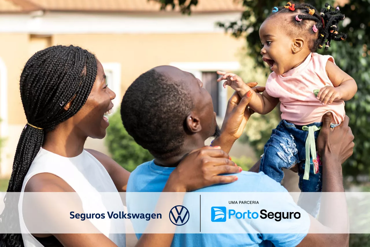 Seguro Volkswagen: uma mulher e um homem sorriem e brincam com um bebe.