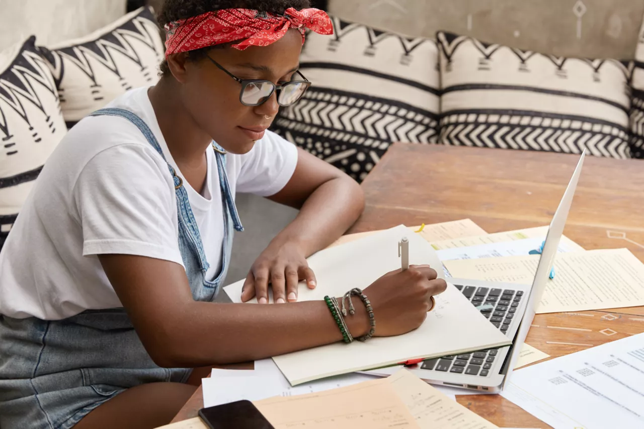 Seguro de Proteção Financeira Volkswagen: mulher sentada na frente do computador estudando.