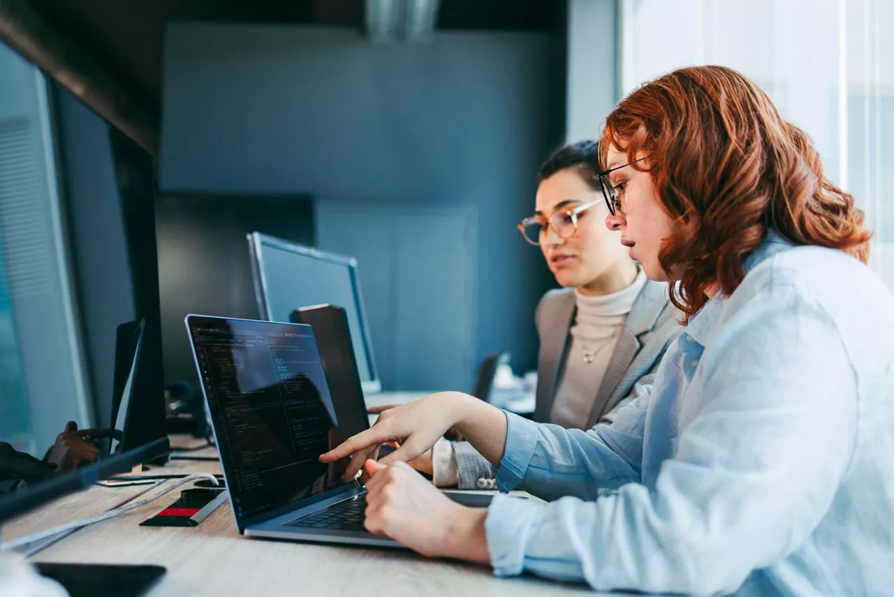 Dos chicas trabajando consultando el ordenador