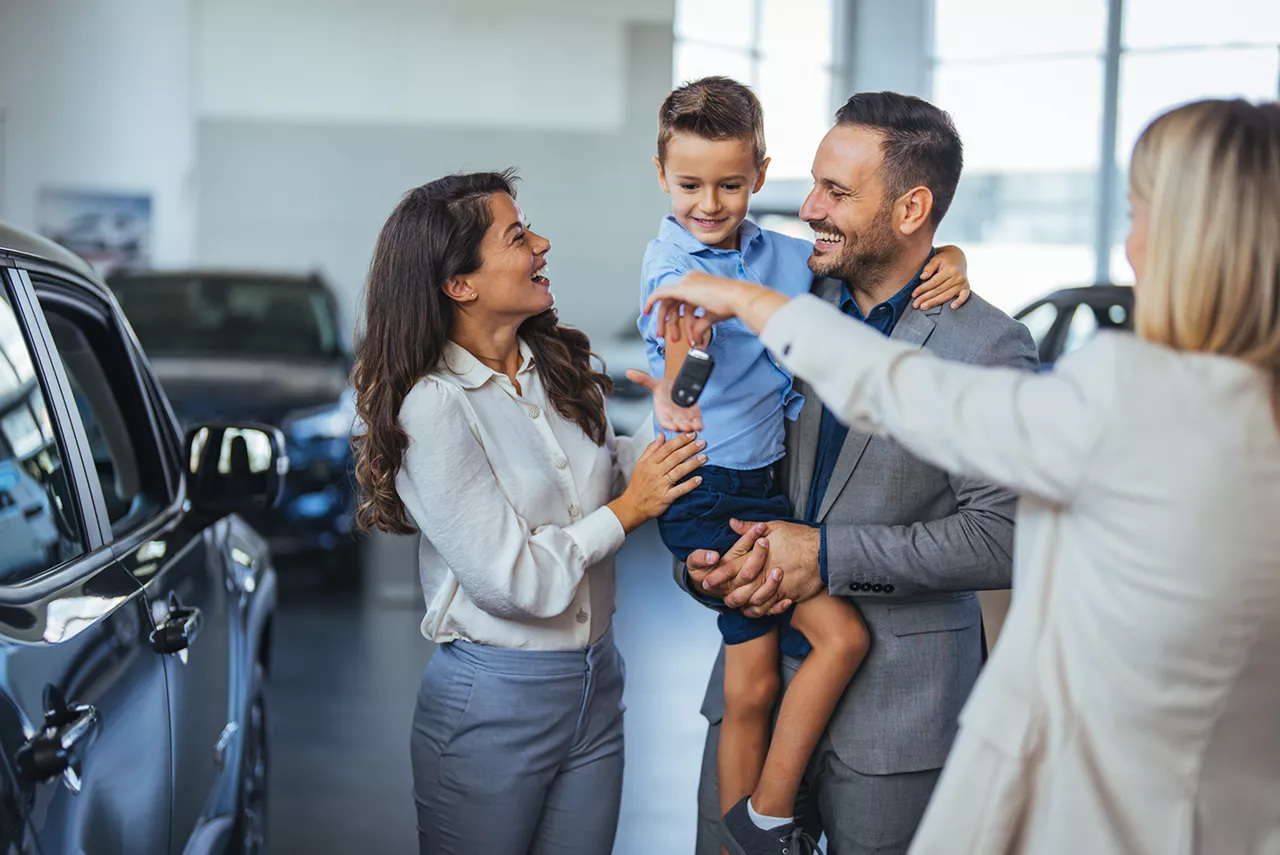 Una familia recogiendo las llaves de un nuevo coche del grupo VWFS