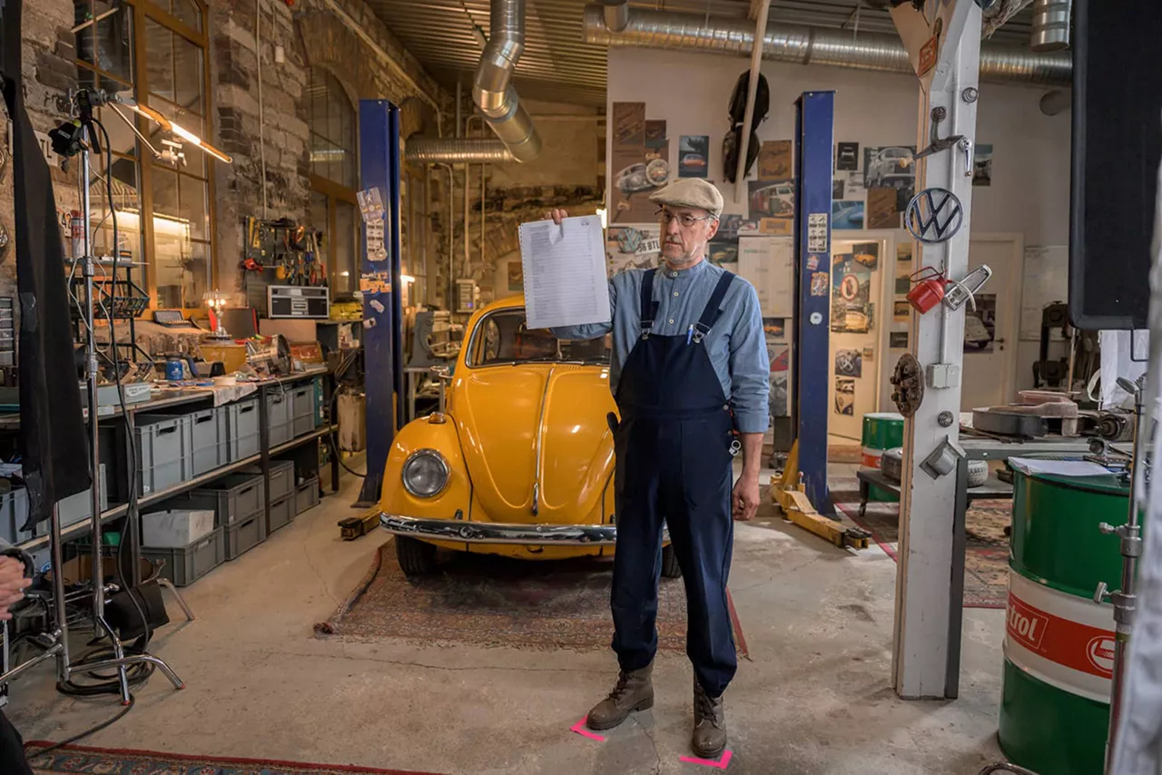 Mann mit seinem Oldtimer in Garage