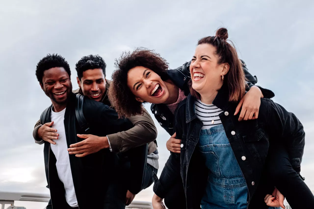 Grupo de personas abrazadas sonriendo