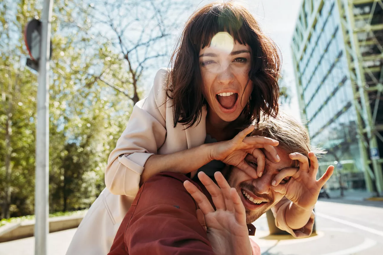 Una pareja joven sonriendo a la cámara en la ciudad