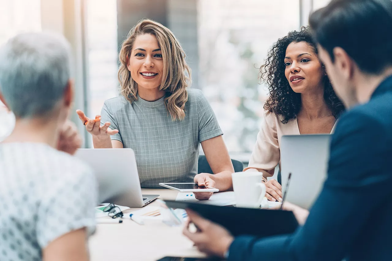 Grupo de personas reunidas en torno a una mesa en la oficina