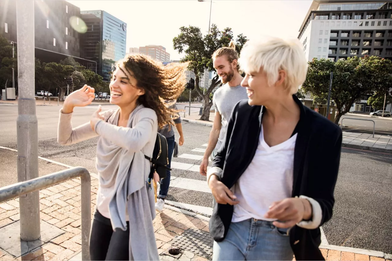 Grupo de personas sonriendo y caminando por la calle