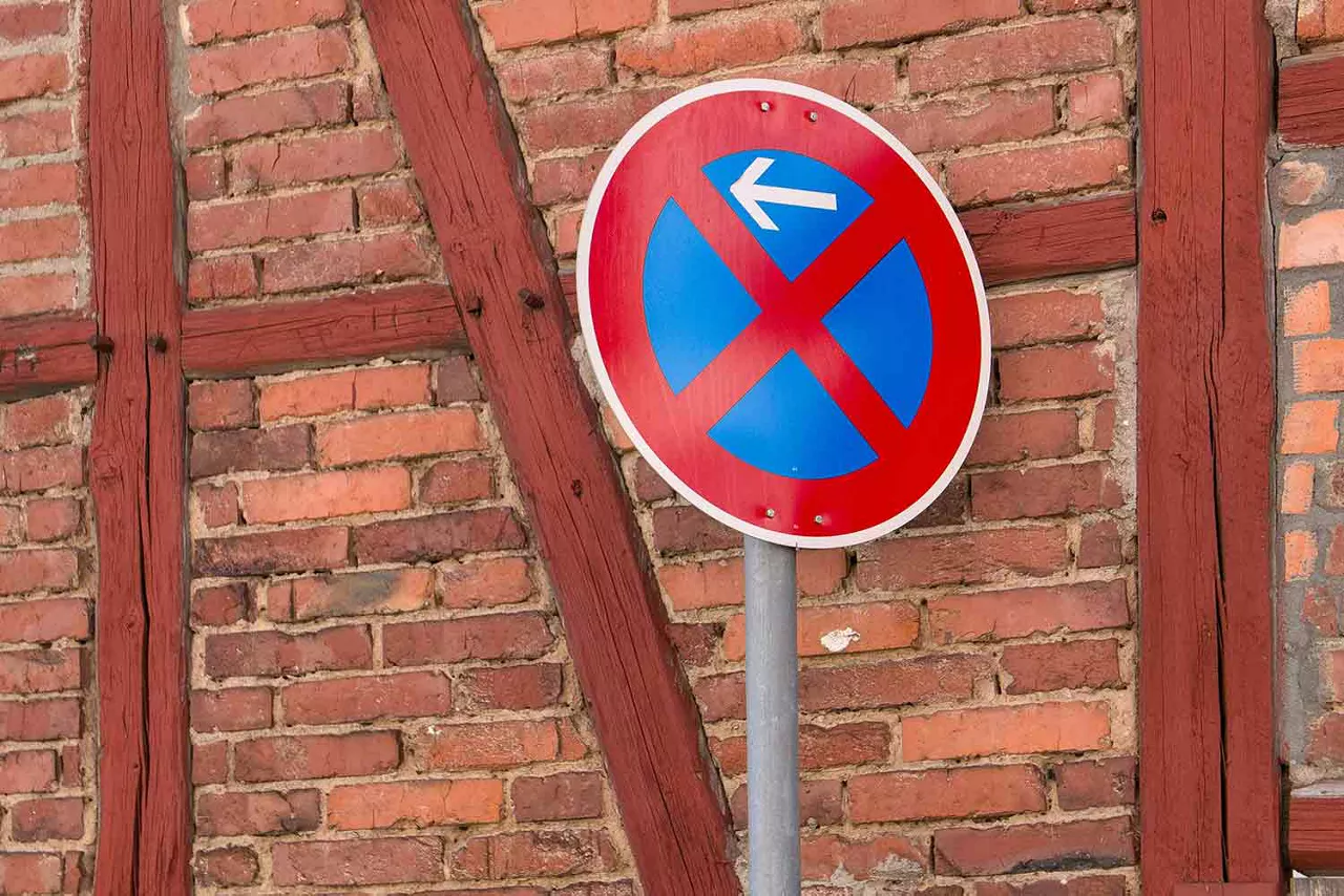 Fachwerkmauer mit einem Parkverbotschild davor