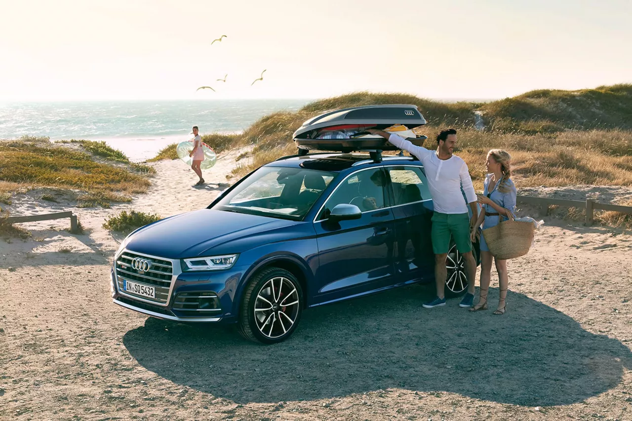 Una pareja con un coche de Rent-a-Car en la playa