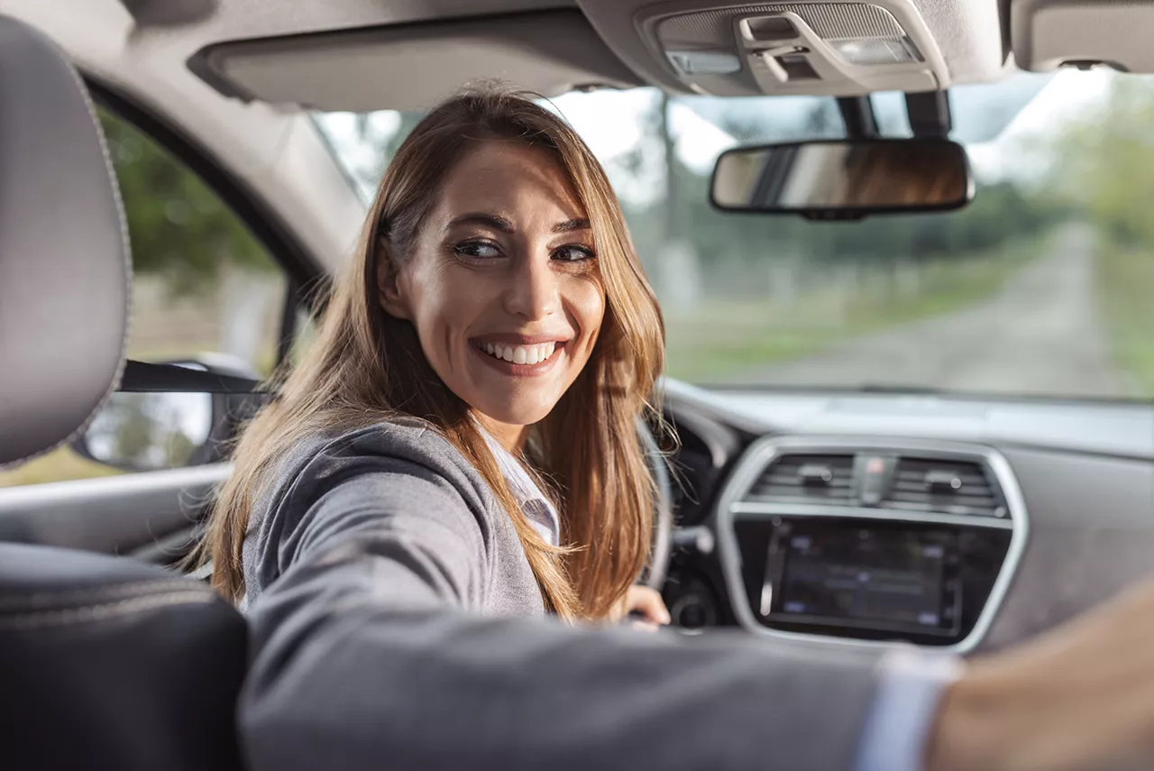 Una mujer sentada en el asiento del conductor de un coche del grupo Volkswagen
