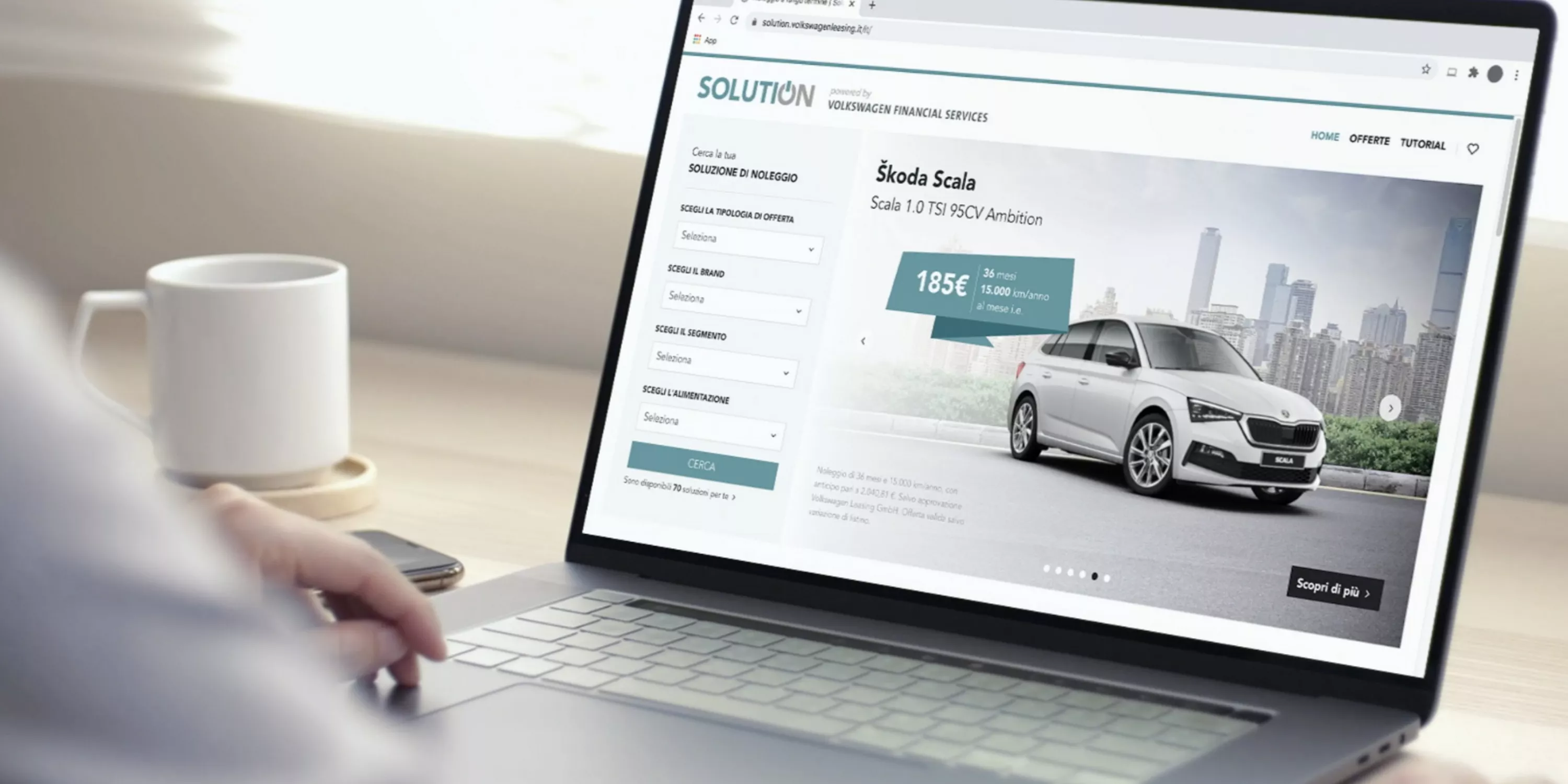 Persona seduta davanti a un computer portatile con il sito web Solution aperto