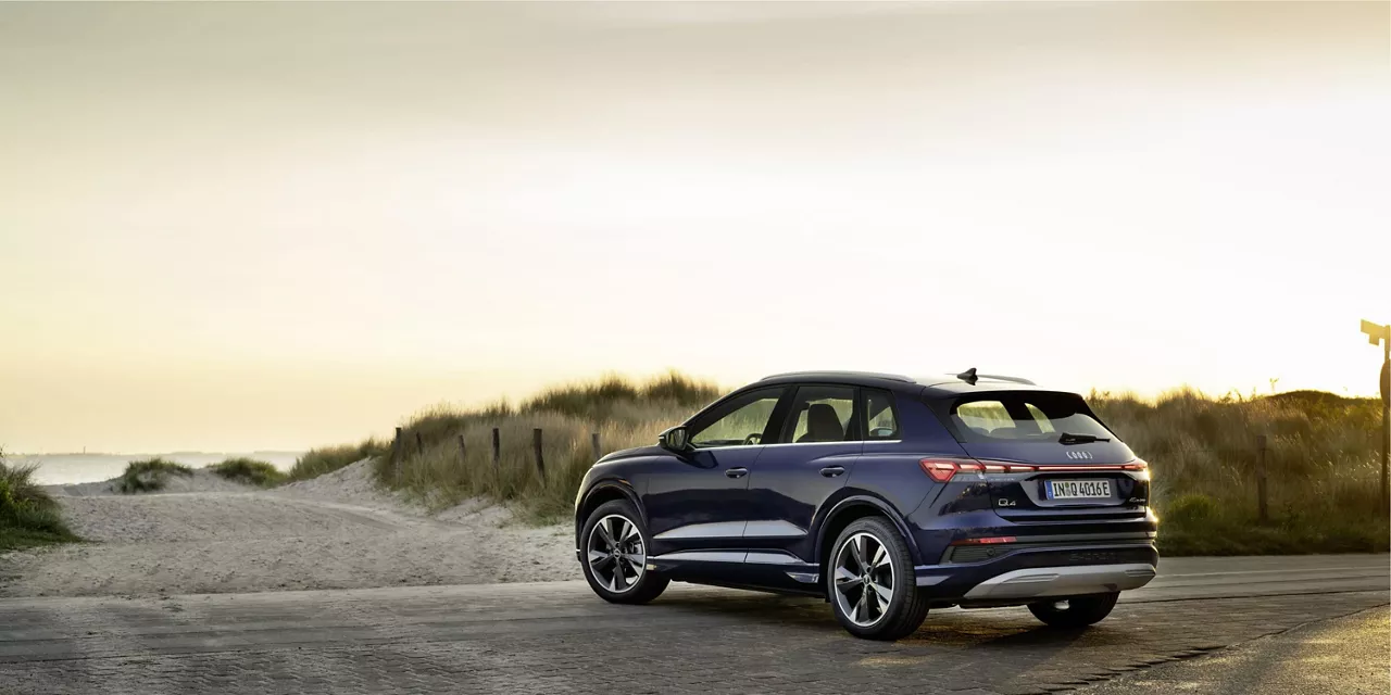 SUV Audi visti desde atras aparcado frente a una playa al atardecer