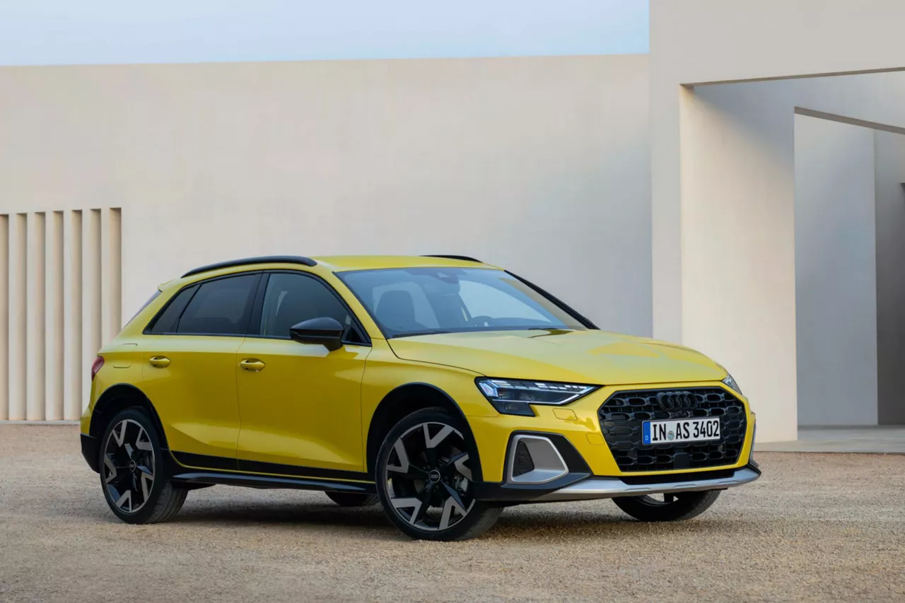 Vista lateral de un coche de Renting Audi A1 Sportback Advanced, diésel, color blanco, aparcado delante de un edificio 