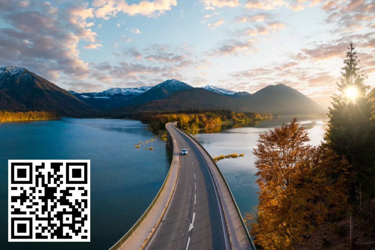 Autopista a través de un lago al atardecer con un código QR sobre impreso