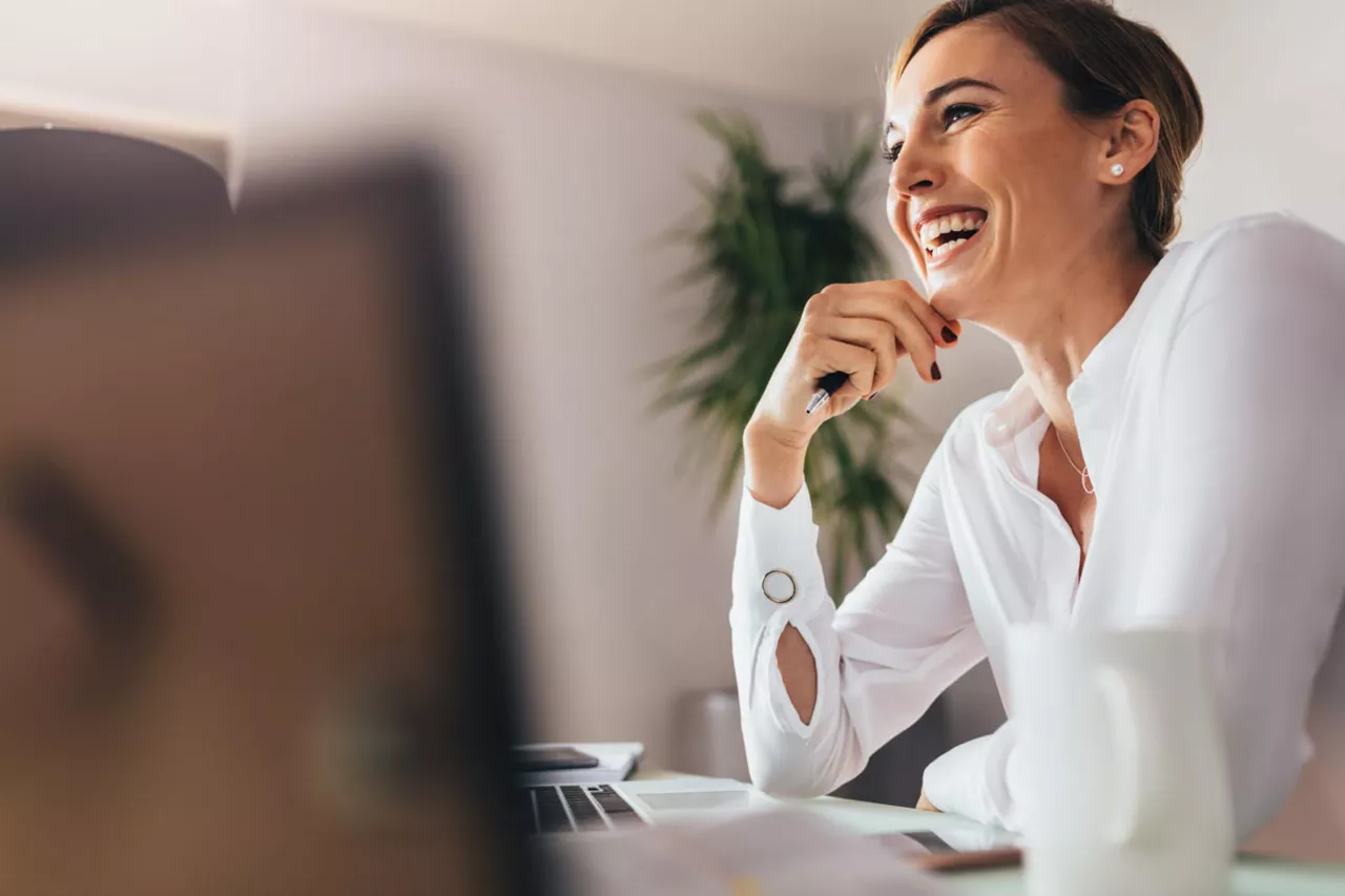 Una mujer sonriendo sentada en una oficina