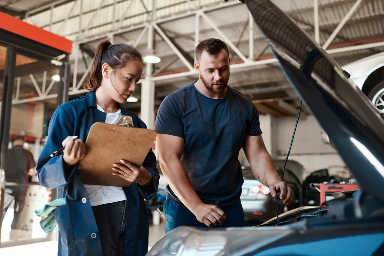 Un mecánico realiza el mantenimiento de un coche en un taller oficial del Grupo Volkswagen