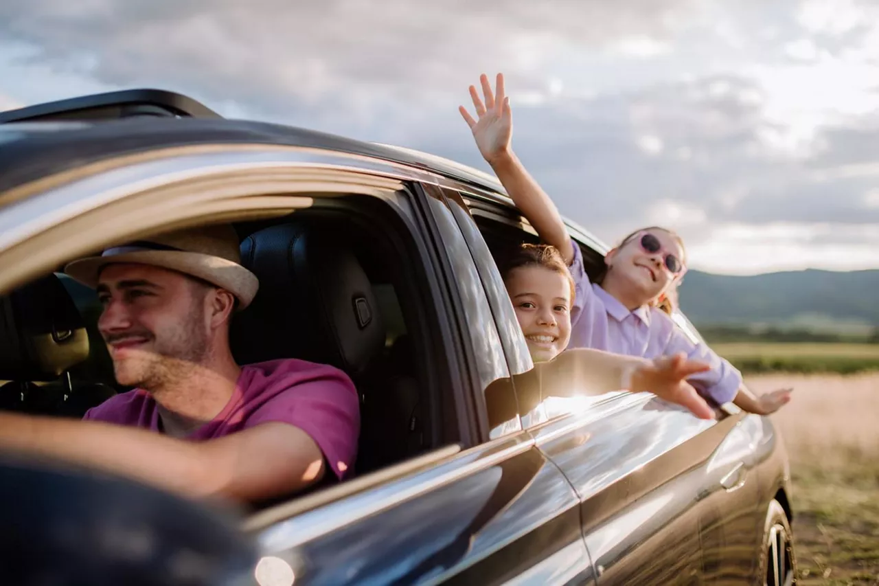 Una familia viajando en un coche de Rent-a-Car del Grupo Volkswagen vistos desde afuera