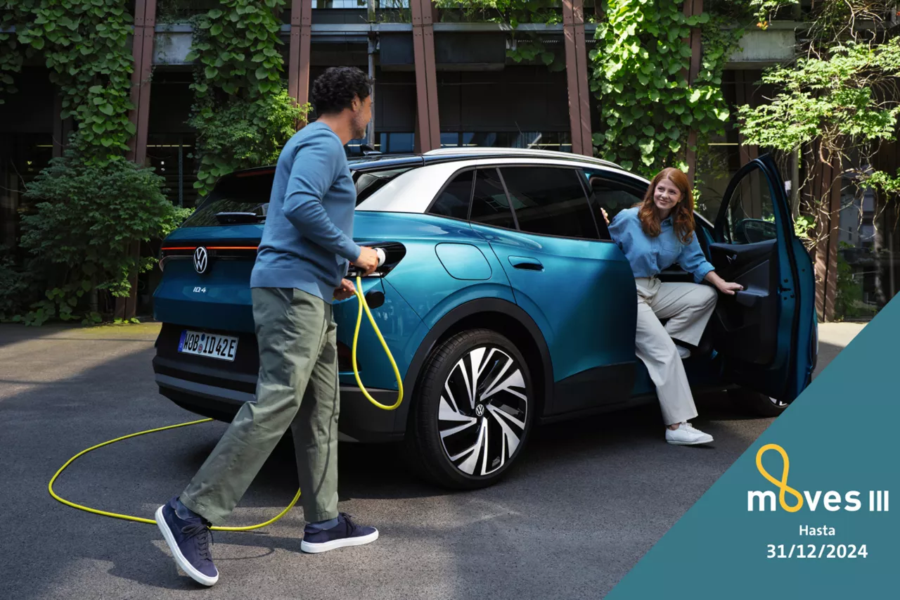 Una pareja junto a un coche eléctrico del Grupo Volkswagen