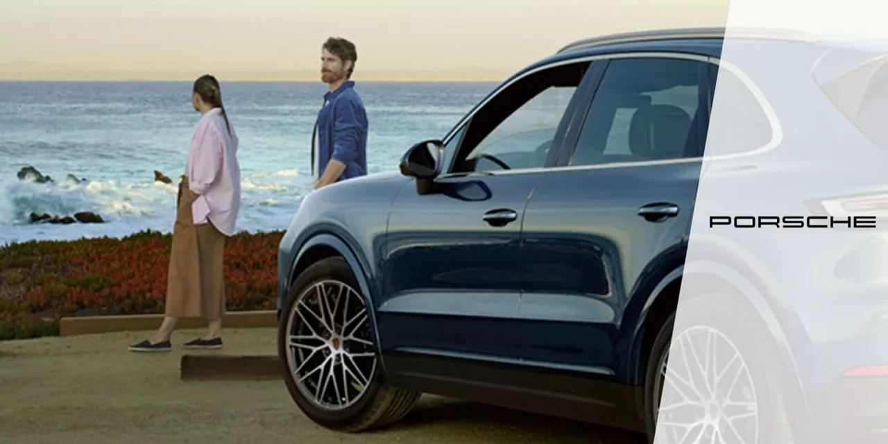 Alquiler de coche: una pareja con un Porsche de Rent-a-Car frente al mar. Alquiler Porsche.