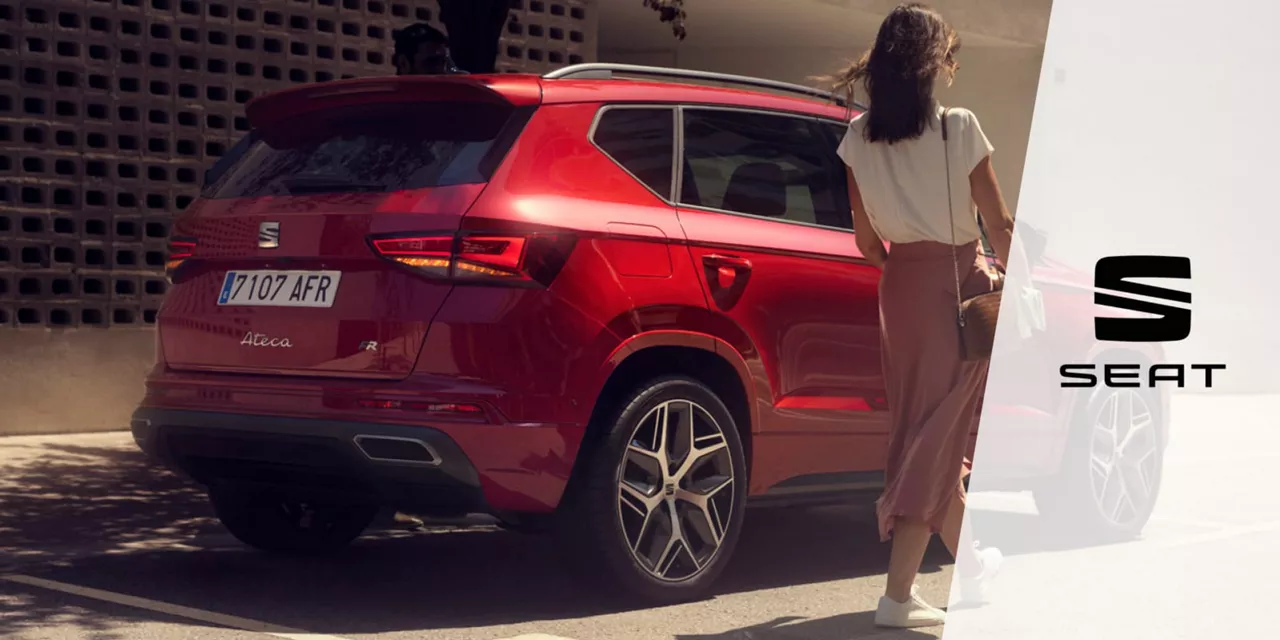 Una chica junto a un SEAT rojo de Rent-a-Car aparcado. Alquiler SEAT.