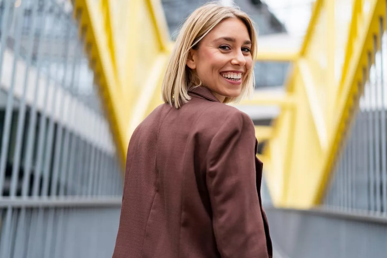 Una chica sonriendo mirando hacia atrás mientras camina