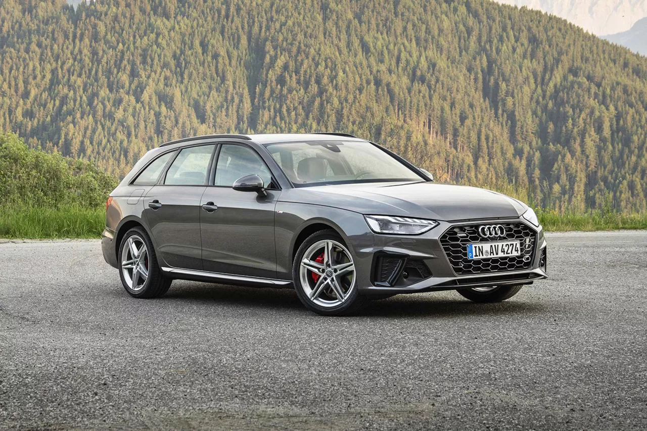 grauer-audi-a4-avant-steht-schräg.auf-asphalt-mit-berglandschaft-im-hintergrund