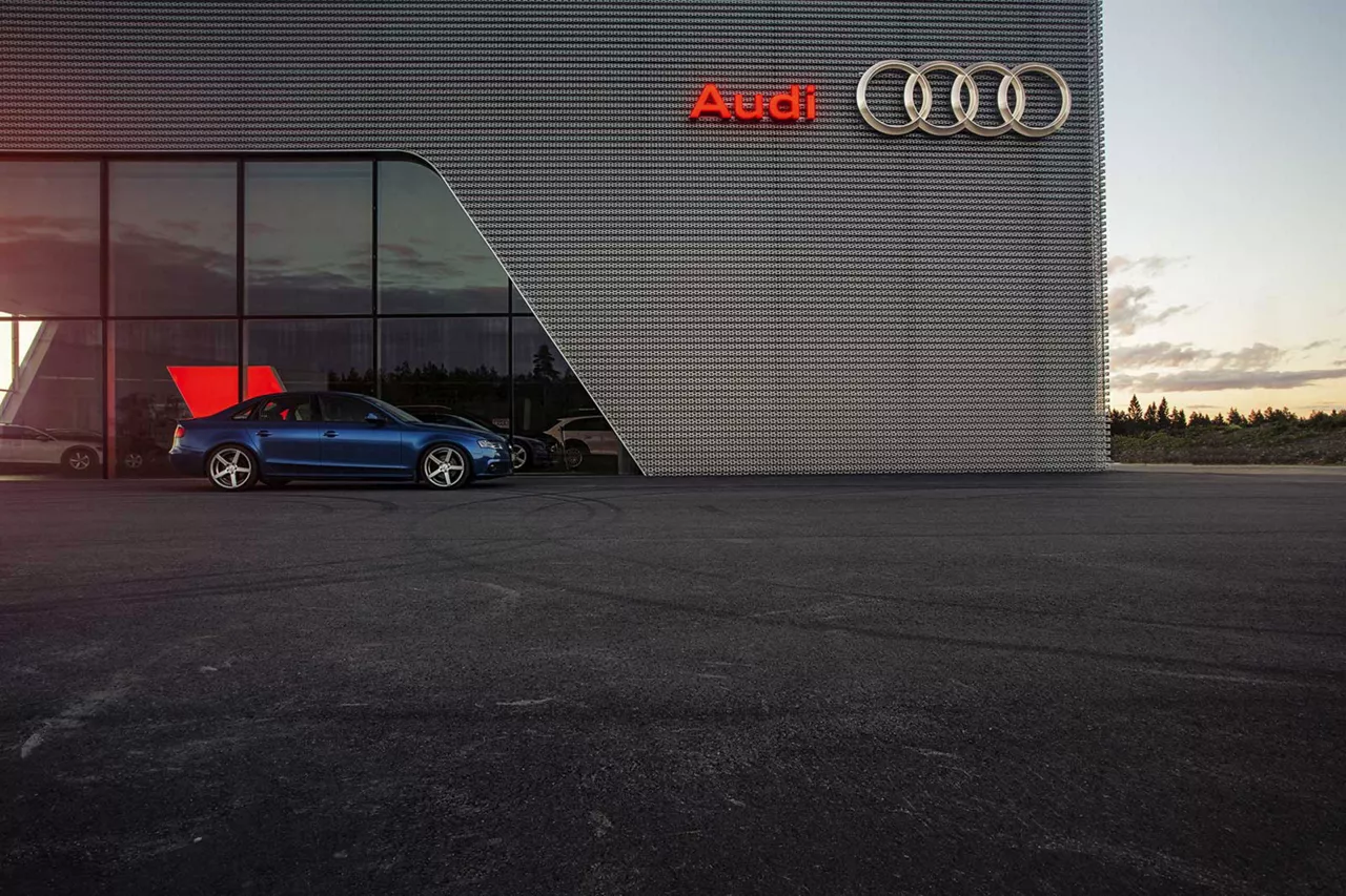 blauer-audi-steht-vor-gebäude-eines-audihändlers