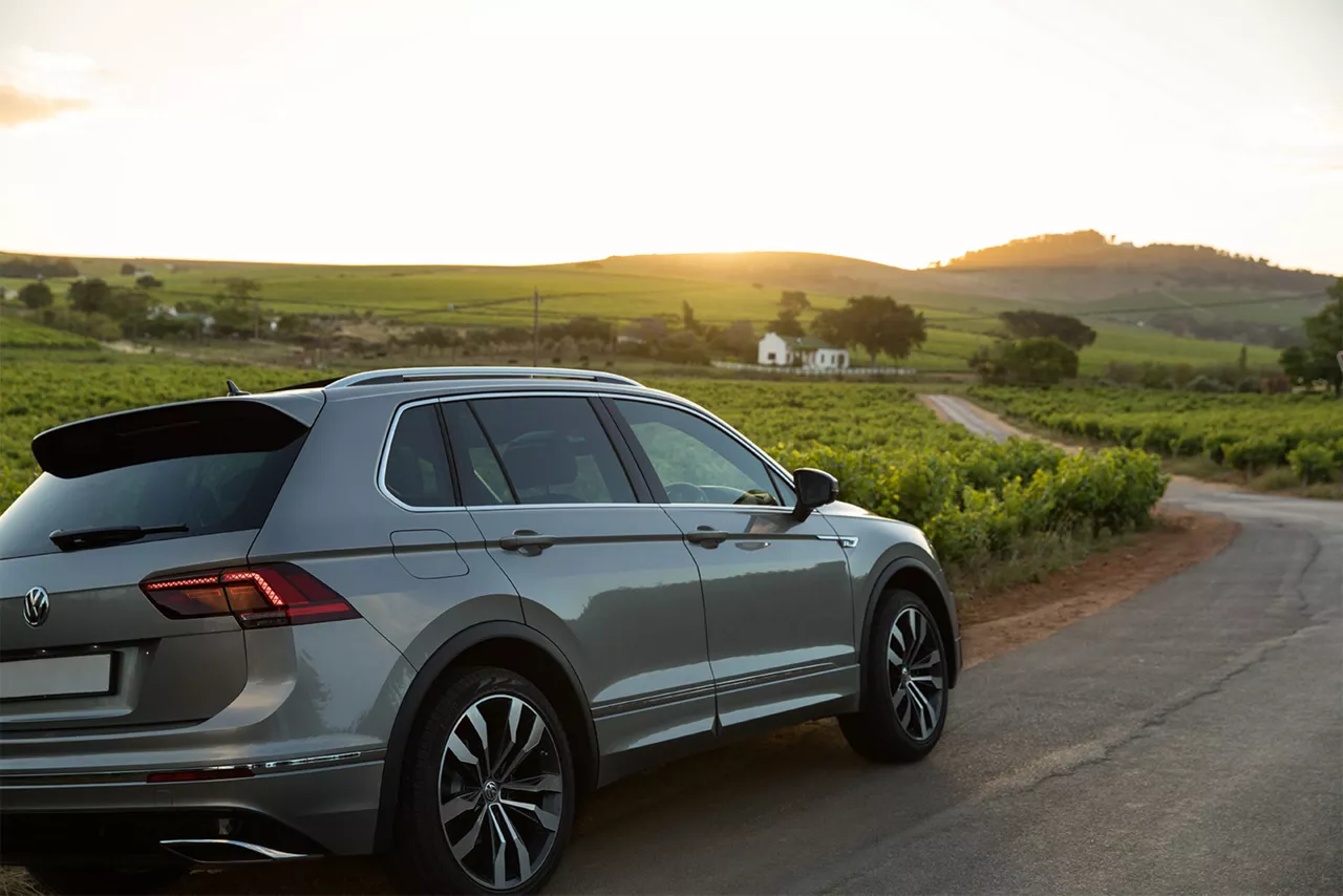 silberner-vw-tiguan-steht-am-strassenrand-bei-sonnenuntergang