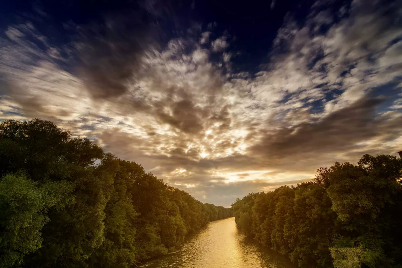 blick-von-der-ulrichsbruecke-auf-fluss-mit-baeumen-drum-herum-bei-sonnenuntergang