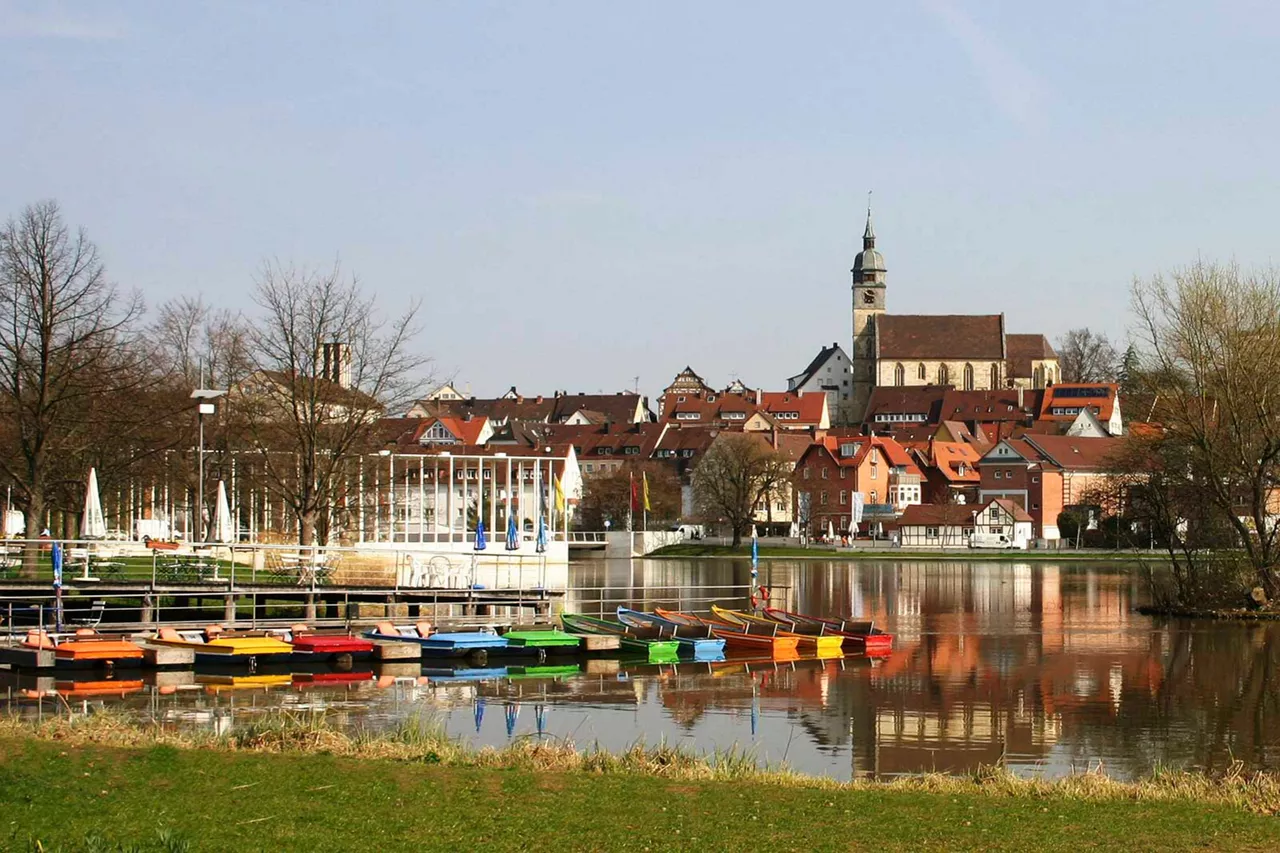 bunte-boote-auf-dem-wasser-an-einem-anlieger-vor-historischen-gebäuden