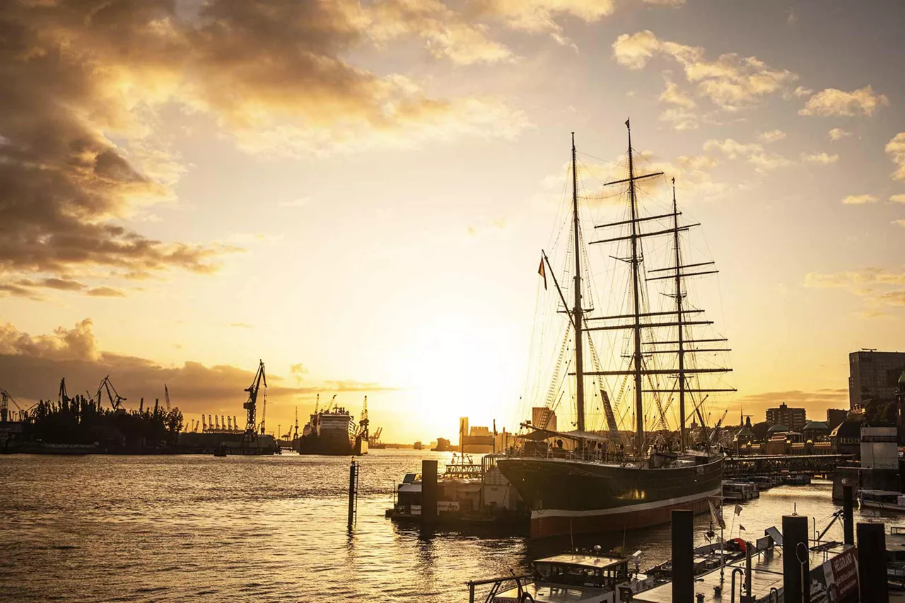 grosses-segelschiff-liegt-im-hamburger-hafen-bei-sonnenuntergang