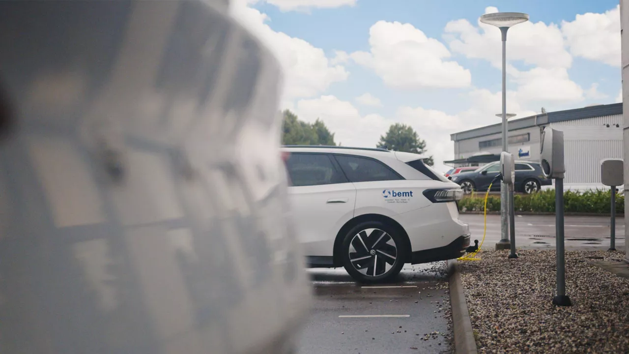 En bemt-profilerad elbil står parkerad och laddar.