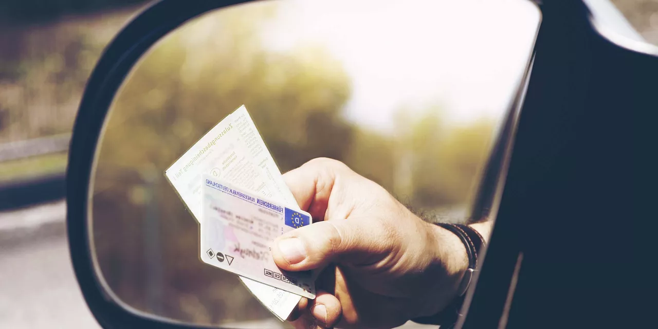 fahrer-eines-fahrzeuges-reicht-papier-aus-dem-fenster