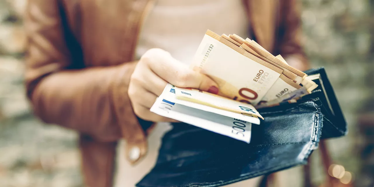 person-holt-geldscheine-aus-dem-portemmonaie