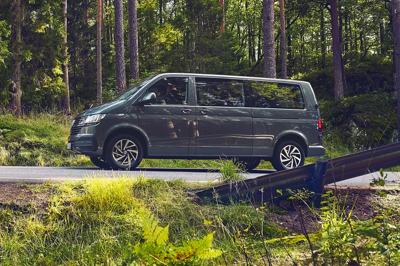 vw-caravelle-fährt-auf-asphaltierter-waldstrasse