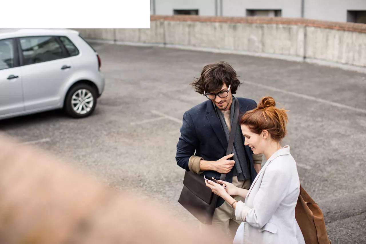 Paar nutzt CleverMobil-App auf Parkplatz