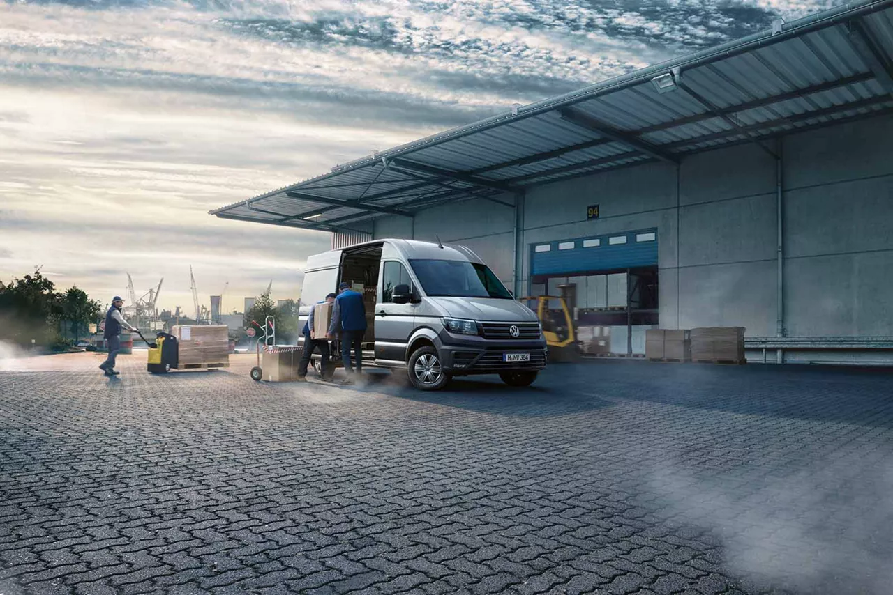 Personen beladen einen VW Crafter vor einem Industriegebäude