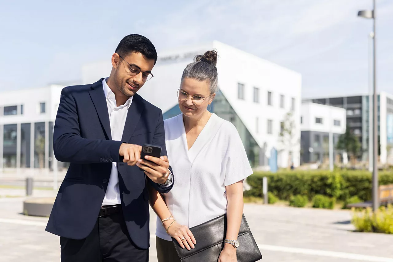 Homme qui discute avec femme et lui montre quelque chose sur son téléphone