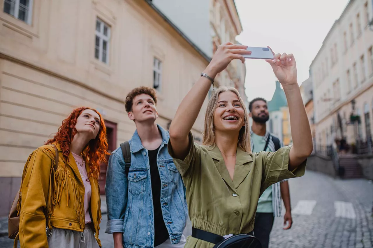 Freundesgruppe steht für ein Selfie in einer Gasse einer Innenstadt