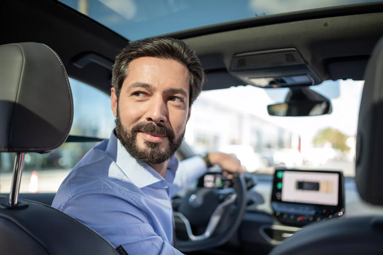 Fahrerin im Dienstwagen macht Schulterblick.