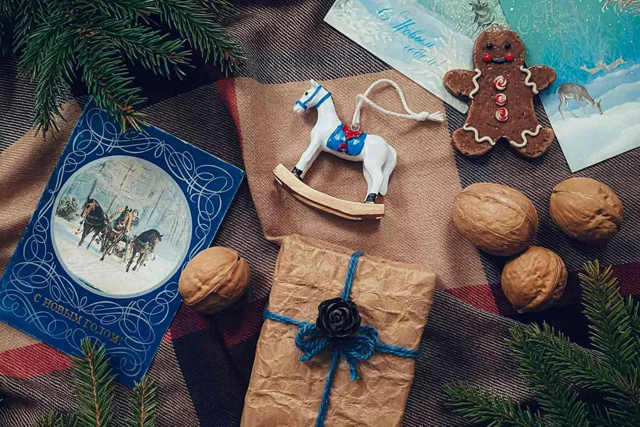 Weihnachtskarten, Walnüssen, Deko-Schaukelpferd und Lebkuchen liegen auf einem Tisch.