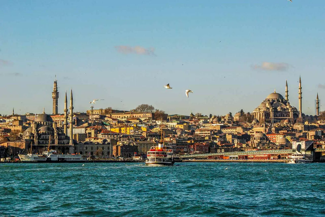 Skyline von Istanbul mit Moscheen, Minaretten, Bosporus und Booten im Vordergrund bei Tageslicht